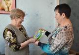 Соцработник Ольга Быльдина (справа) вручила новогоднюю открытку пенсионерке Любови Дмитриевне Одеговой