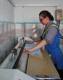 Сестра-хозяйка Инна Лоскутова утюжит белье на гладильном катке