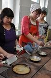 Преподаватель Тамара Борисовна Мельникова учит печь блины с припёком студенток Кристину Осипову и Арину Федькову
