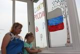 Жительница Камень-Рыболова Ирина Крылач с четырёхлетней дочерью Яной на окнах своего балкона изобразили российский триколор и белую берёзу