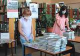 Сотрудники библиотеки Елена Василькова и Евгения Кириченко разбирают книжные новинки, пополнившие фонд центральной библиотеки